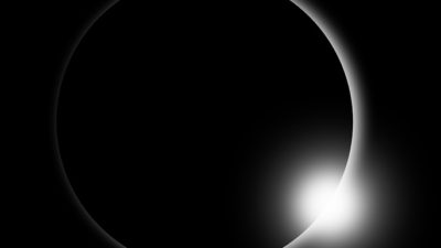 Månen har skymt det mesta av solen och bara en svag strimma ljus lyser förbi månen.