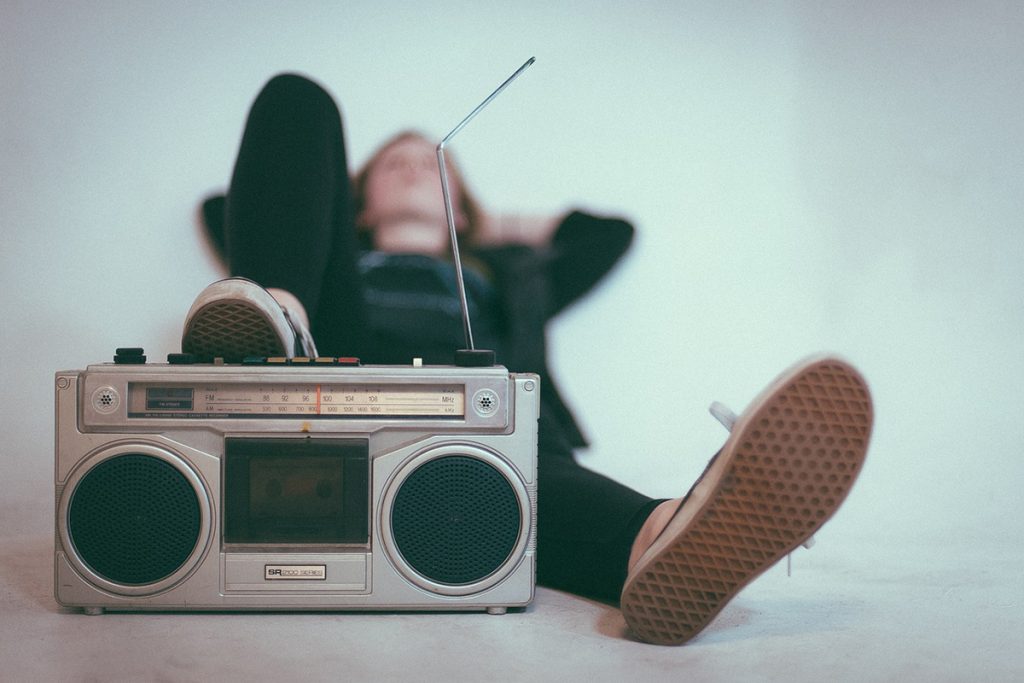 En gammal radio och någon som lyssnar på den.